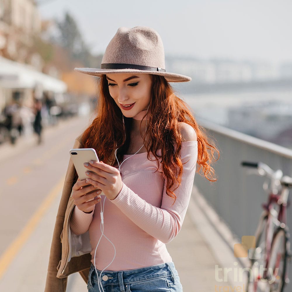 Jovem ao celular com eSIM da Trinity Travel